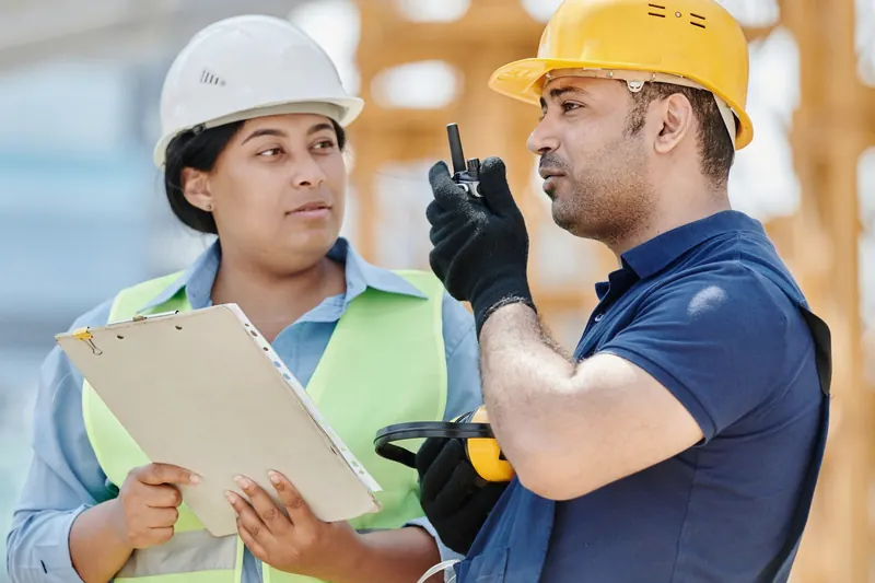 Two construction workers in protective equipment.