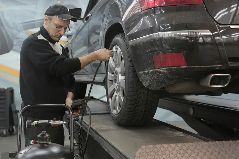 Automotive service bay with a vehicle on a lift.
